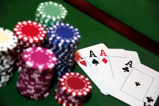 green casino table four aces in a poker game and a big pile of chips
