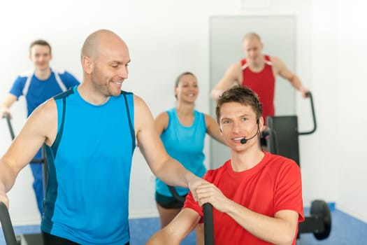 Young fitness instructor lead class treadmill alpinning at the gym