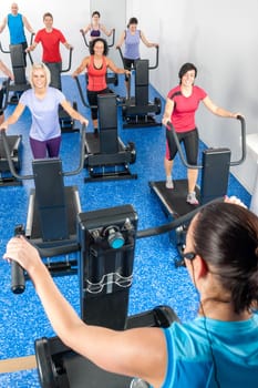 Fitness instructor leading treadmill running class at health club