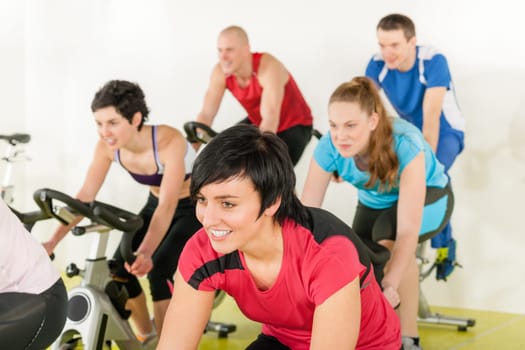 Fitness group of people on bicycle doing spinning at gym