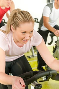 Young woman at bike spinning class enjoy cardio training