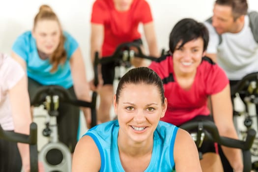 Smiling woman at spinning class fitness workout people exercise