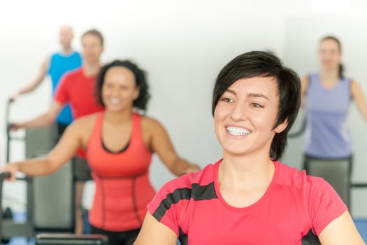Smiling woman at fitness class gym workout on treadmill