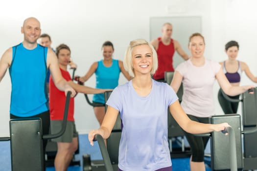 Fitness young group on treadmill running trainer at health gym