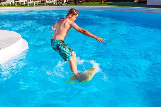 boy has fun jumping in the pool