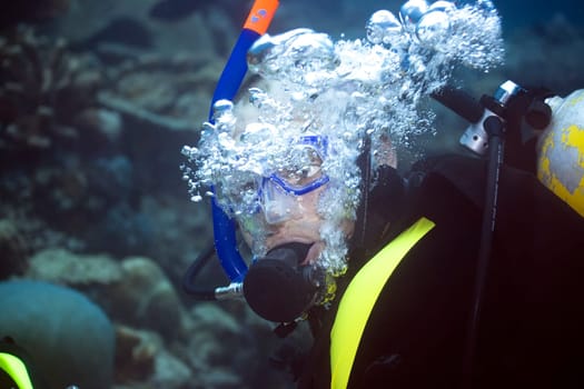 Diver underwater making bubbles.