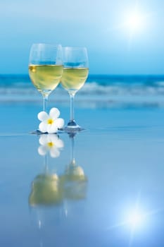 Reflection of two glasses of white wine on tropical beach