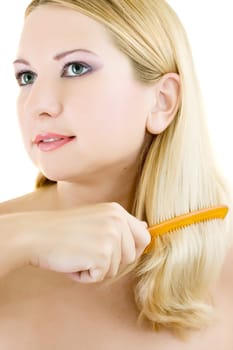 Young woman with hairbrush on white background