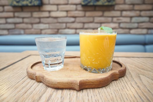 Two drinks presented on a wooden tray in a warm, inviting environment.