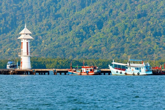 Lighthouse on a pier by a village on Koh Chang Island in Thailand