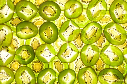 Background laid out in two layers from whole kiwi slices