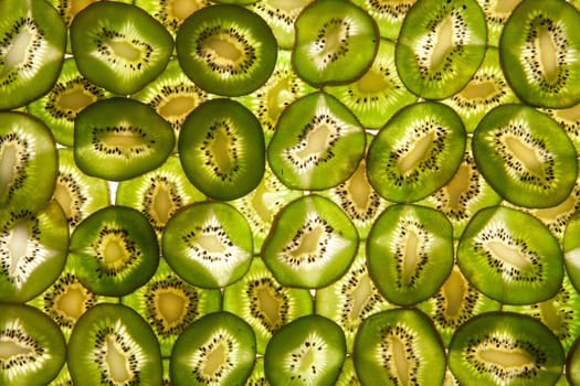 Background laid out in two layers from whole kiwi slices