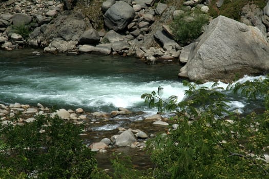 River flowing through boulders, rocks and pebbles