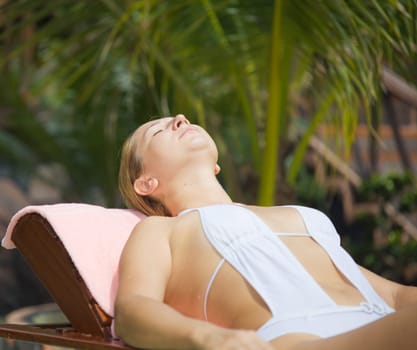 Young woman sunbathing on the chair