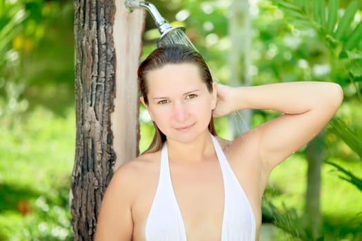 Young beautiful woman taking a shower outdoor
