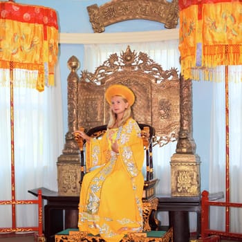 Woman in tradicional asiasn clothes sitting in chair