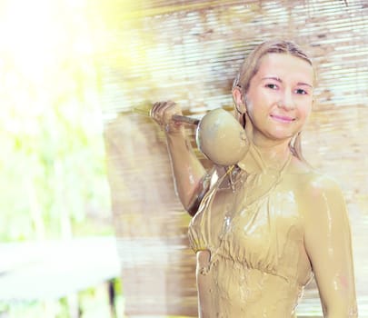 Young woman mudbathing outdoor.