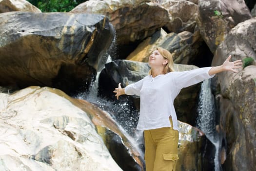 Young woman have a fun over waterfall background