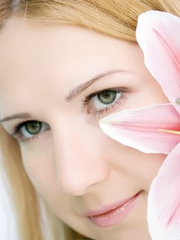 Face of young woman with lily flower