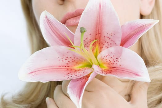 Lily flower in woman hands near face
