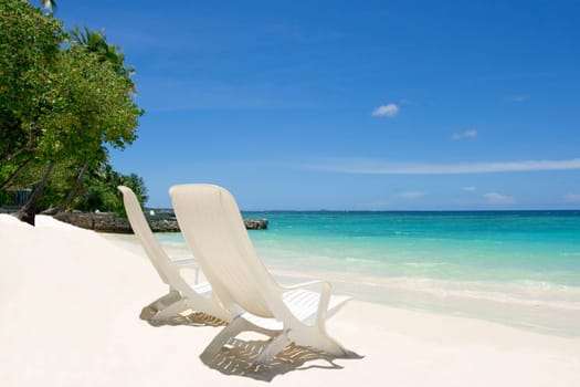 Two empty beach chairs. Coast of Indian ocean. Maldives
