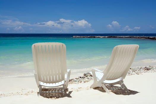 Two beach chairs on a clean, sunny beach. Maldives