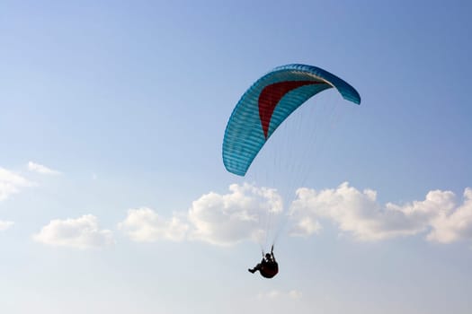 Paraglider with cian wing in the sky