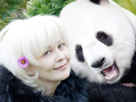 Blondy woman in clothes with black fur and panda