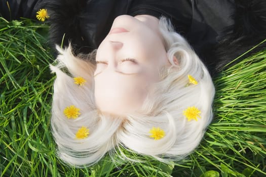 Beautiful young woman relaxing on the green grass