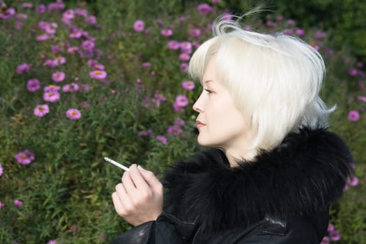 Young woman is smoking on flower background