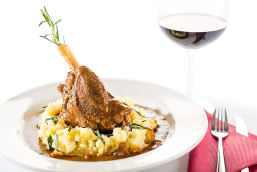 Lamb knee in sauce with mashed potatoes on white background