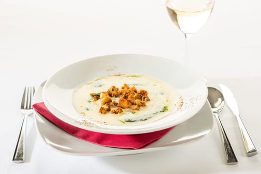 Creamy soup with garlic, spinach and croutons in white plate