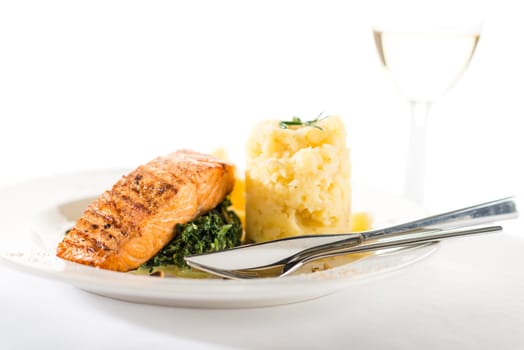 Salmon steak with spinach and mashed potatoes isolated on white