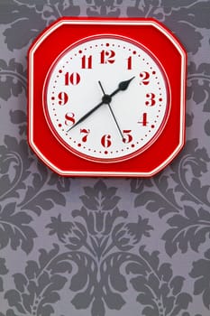 Retro clock on floral wallpaper