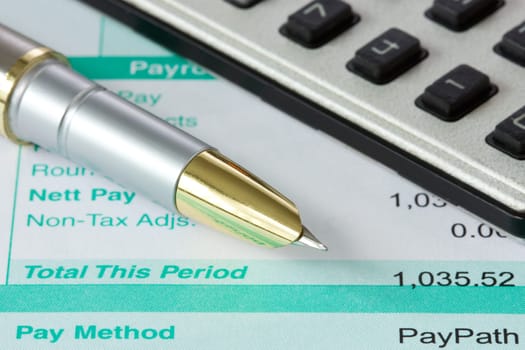 ink pen, calculator and payroll summary details
