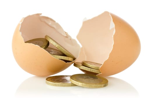 Broken  eggs with coins on white background