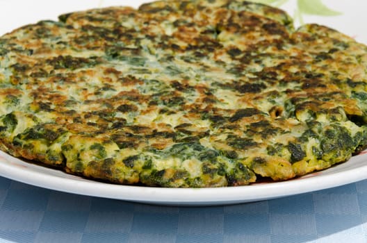 vegetable frittata just baked on white plate