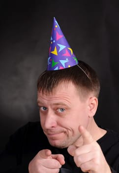 happy man in the festive hood on the dark background