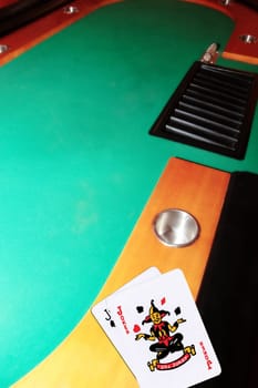 green casino table with copy space and the jack of spades and joker representing a blackjack game