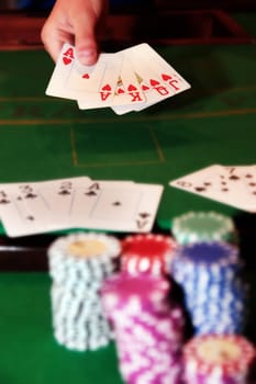 royal flush has poker player showing winning hand of cards with the chips in the foreground