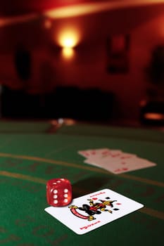 green casino table with dice on a joker and a hand of a royal flush