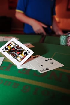 poker player throwing in cards with the jack of clubs in the foreground