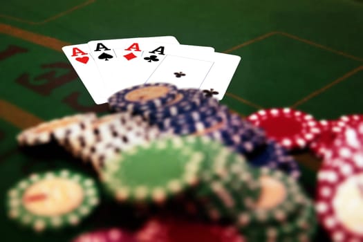 green casino table four aces in a poker game and a big pile of chips