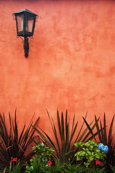 A red colonial wall with a lantern in the upper left.