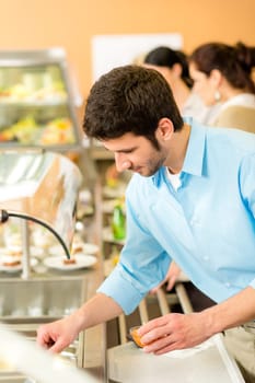 Business man take cafeteria lunch food from display cabinet self-service