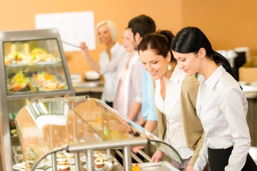 Cafeteria lunch two office colleagues woman choose food dessert self-service