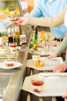 Desserts at cafeteria people with serving tray self service canteen