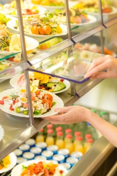 Fresh salad buffet self-service food display human hand take plate