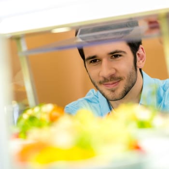 Cafeteria food display cabinet young man choose salad healthy lifestyle