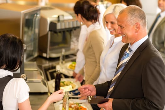 Cafeteria man pay by credit card cashier food on serving tray